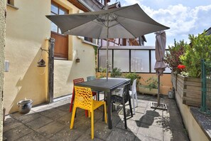 Grande terrasse de 20m² avec table à manger et parasol