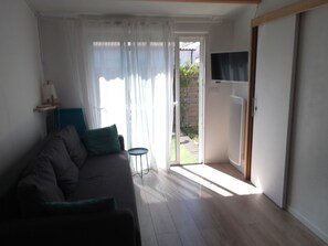 Le séjour, ouvert sur la terrasse ensoleillée, avec TV réception TNT.
