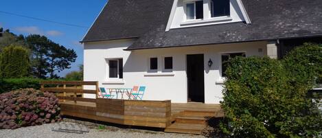 la façade avant de la maison, avec la nouvelle terrasse en bois.