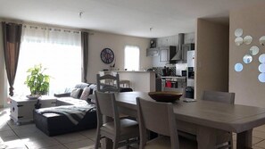 Pièce à vivre avec cuisine américaine équipée, salon et salle à manger 