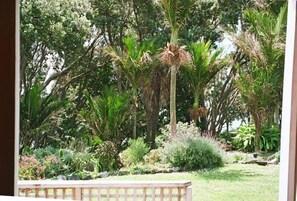 View of foliage from house and deck with beach below via track