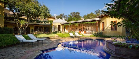 Pristine pool with hot tub and fountain that overlook it.