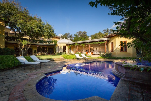 Pristine pool with hot tub and fountain that overlook it.