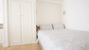 Queen-size bed in alcove with guest clothes cupboard