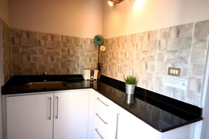 Kitchen with toaster, kettle, coffee machine, microwave. 2 hobs, small fridge.