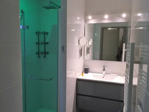 Badkamer met regendouche met kleuren ledverlichting, wastafel, vloerverwarming