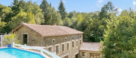 Swimming pool overlooking the gites and the playing fields and woods beyond