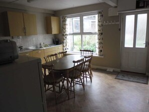 Well equipped kitchen, door leading to back garden and outside toilet.