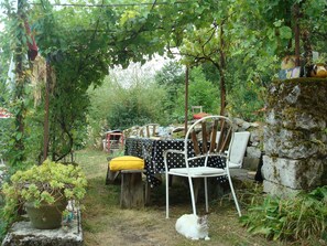La terrase à l'ombre de la vigne et du chèvrefeuille