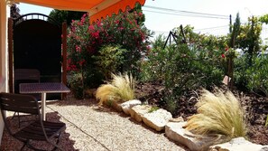 Terrasse privée avec jolie platebande et store 