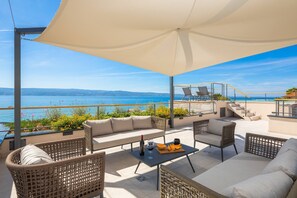 Dachterrasse mit Lounge-Sitzecke und Whirlpool mit offenem Blick auf die Adria
