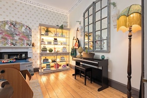 Games room with books, Freeview TV, Yamaha piano and acoustic guitars