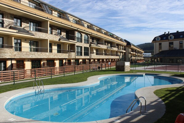 Vista de piscina exterior y urbanización Costa Reinante Spa.