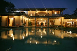 Pool & villa at twilight. Enjoy the fly-past of up to 1000 fruit bats.
