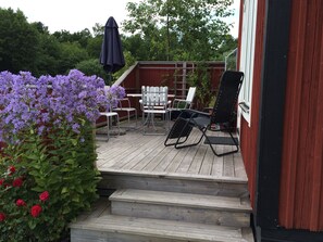 Patio facing west (evening sun) has dining table and sun chairs.