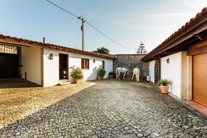 Casa do pátio à esquerda e cavalariças à direita