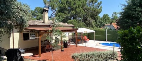 Jardín/terraza, zona piscina, solárium y mesa bajo pérgola