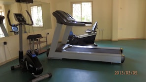 Gym with various exercise equipment, TV, fan, A/C