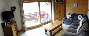 Sitting area with sofa-bed, picture window with sliding door to balcony, & view