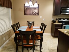 Dining room table for six. Countertop barstools provide seating for two more.