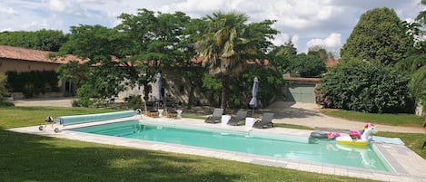 May photo trees not yet in bloom showing inflatables in the heated pool.