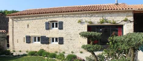 Gite from the garden showing the large sliding doors to the lounge