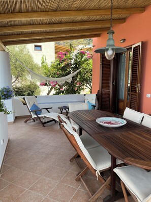 zona pranzo e sdraio, giardino sullo sfondo