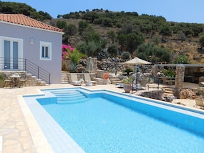 Villa Eleni pool, sun loungers, and dining and barbeque terrace.