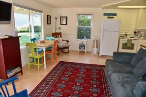 The living room has a small dining area and flows into the kitchen