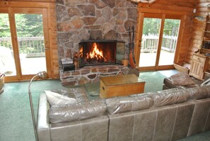 Living room with raised hearth fireplace and 2 french doors to deck 