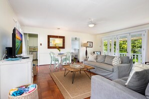 The bright and airy living room seamlessly connects to the front and backyard, offering easy indoor-outdoor living.