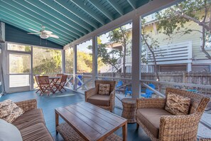 Additional view of the screened in porch, equipped with a comfortable seating area and dining table