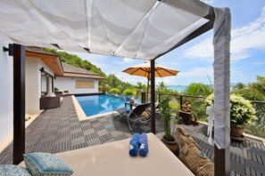 Relax by the pool with the four-poster day bed.