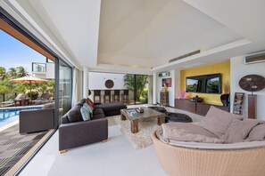 Indoor living room with L-shaped sofa, bean bags, and smart TV
