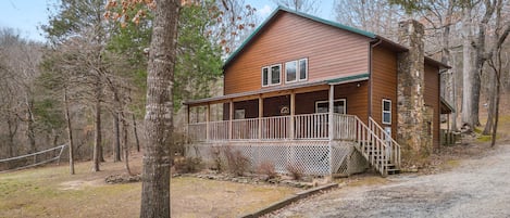 2 story cabin with large front deck overlooking the volleyball net and horseshoe