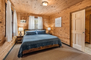 Main level bedroom featuring king size bed. Bedroom attaches to main floor bath