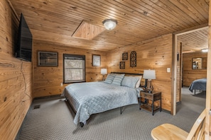 Upstairs bedroom features king bed and 48 inch smart tv for streaming