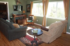 Living room area with TV and mountain views out the windows.