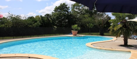 grande piscine chauffée accessible par une plage en pente douce