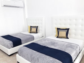 Habitación con 2 camas Queen que permite acomodar a 4 personas, incluye AC.