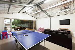 Endless entertainment in the games room with ping pong, a comfy couch, and TV/DVD setup