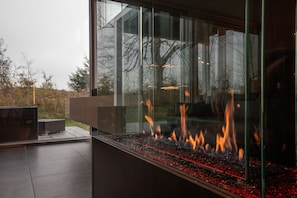 The lounge space features a custom couch, 3-sided fireplace, and great views!