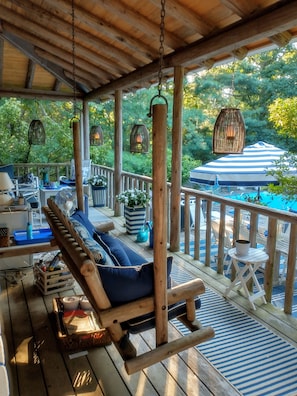 large back porch overlooking pool with swing and seating