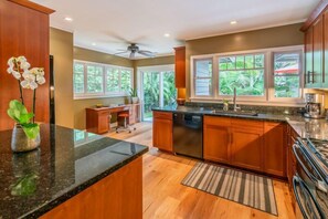 Open concept kitchen offers plenty of space and excellent views of the tropical outdoor landscape