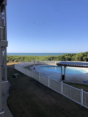 View of ocean and pool from condo balcony.