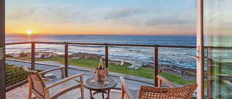 Beautiful balcony with sunset, beach, and ocean views.