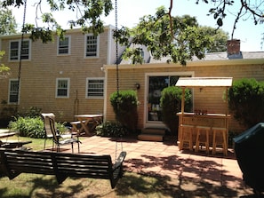 Outdoor patio features TIKI bar, hammock swing chair, picnic table and gas grill