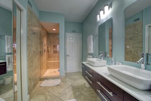 Primary suite bathroom with spa shower, dual vanities and separate toilet.