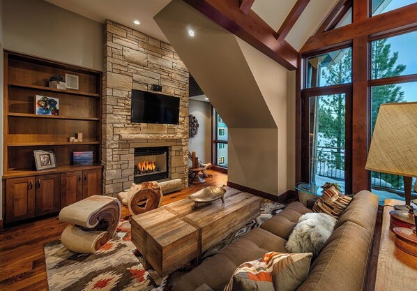 Living room with high ceilings, gas fireplace, QLED HDTV w/ Dolby Soundbar, Cable, Netflix, Amazon Prime Video, Apple TV, Sonos stereo & More