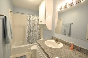 Bathroom has full tub/shower and features granite tile counter-tops.